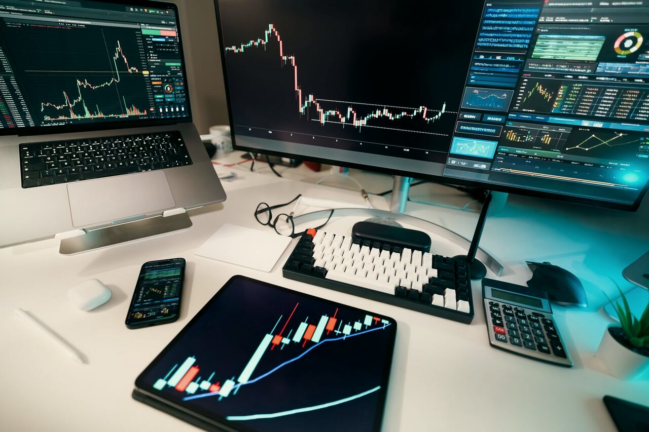 A desk of monitors carrying live charts and transaction data.