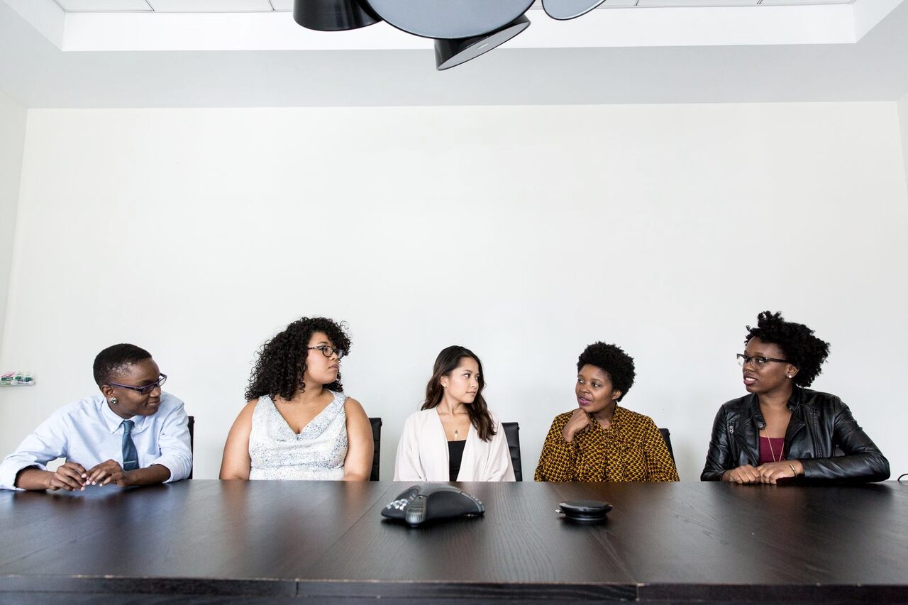 Five professionals seated together at a boardroom table.